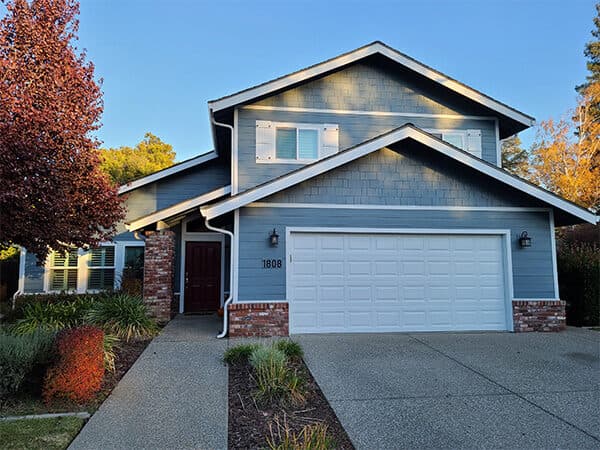 Blue-gray home with horizontal siding, shingle accents, and attached garage