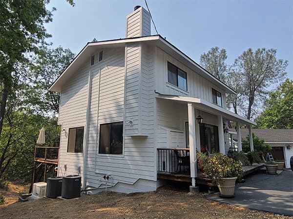 White two-story home with horizontal siding and covered porch